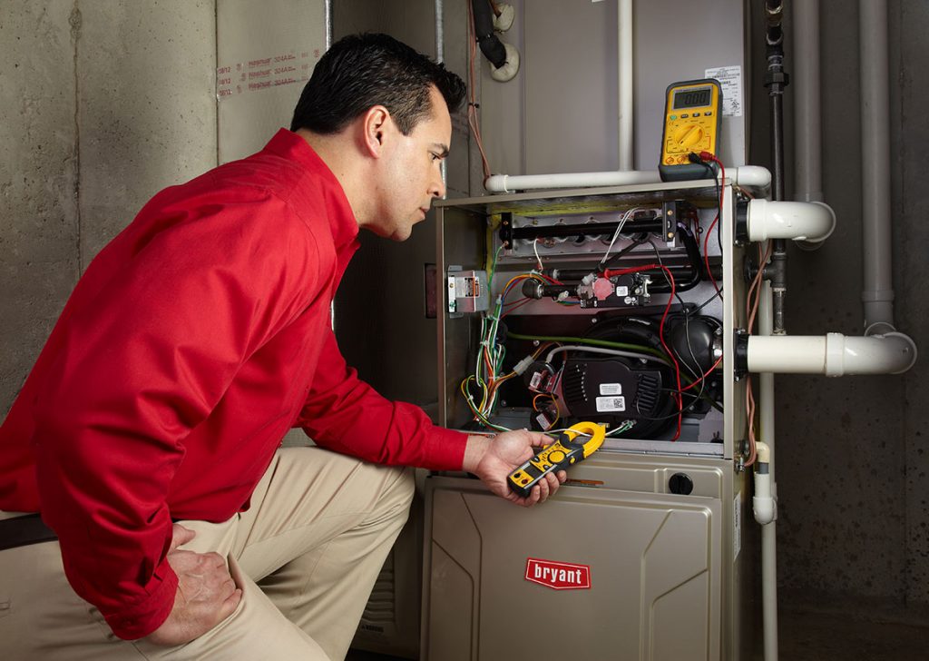 Heating and air conditioning technician servicing an indoor furnace in San Tan Valley, AZ