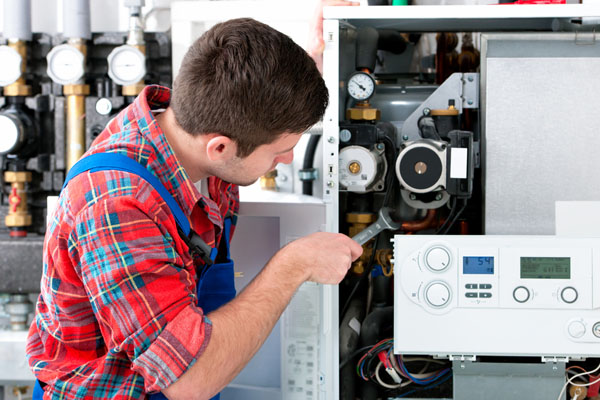 HVAC technician inspecting an indoor heating system in San Tan Valley, AZ