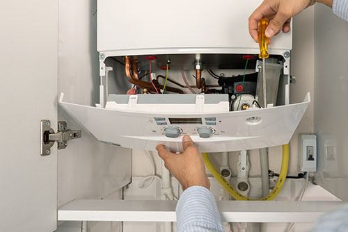 HVAC technician repairing an indoor boiler in San Tan Valley